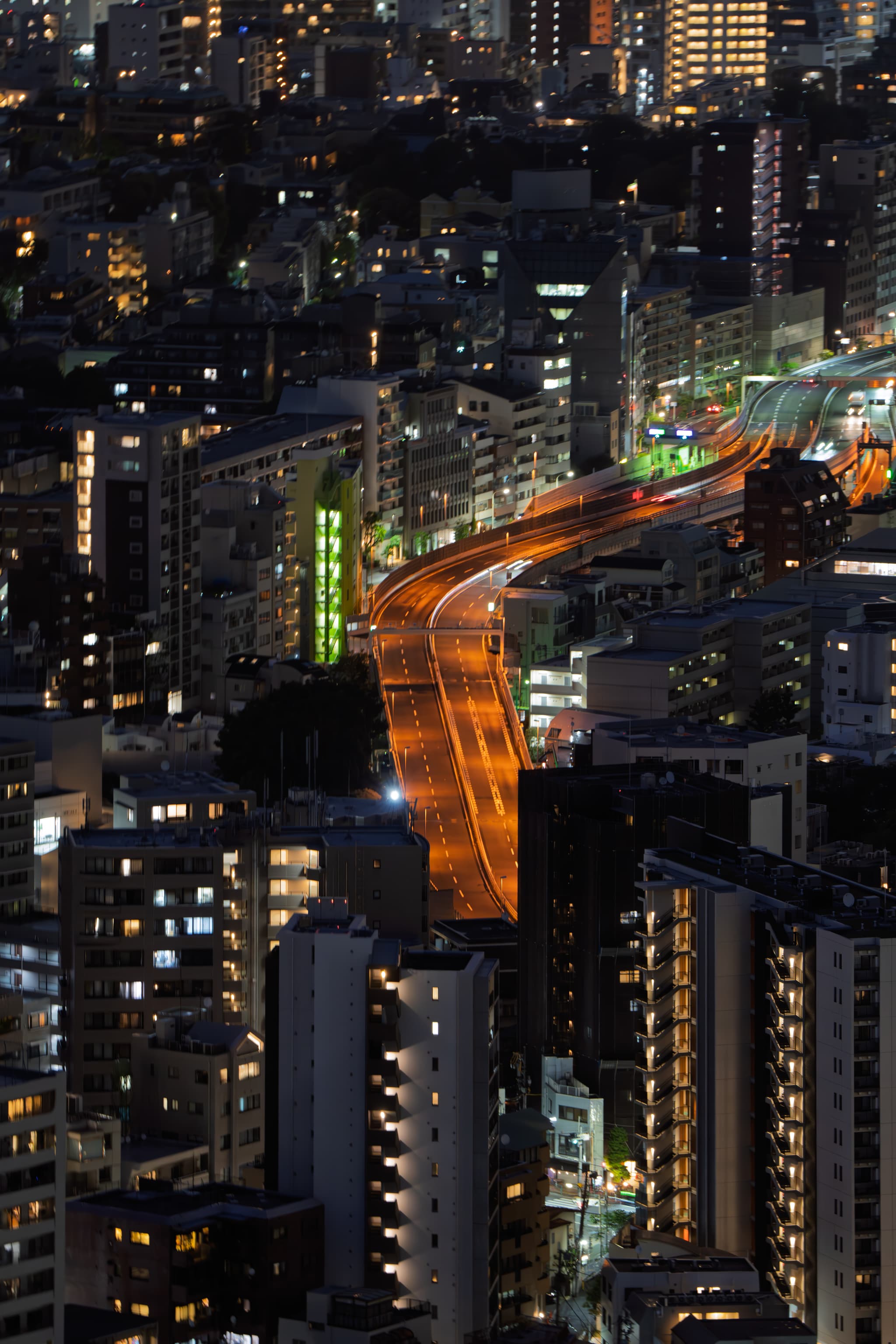 城市夜景，高楼林立，街道灯光明亮，呈现出繁华的都市氛围。